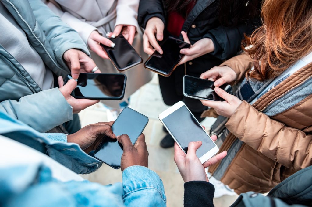 Group of friends addicted to mobile phones to share on social media network and stay in touch