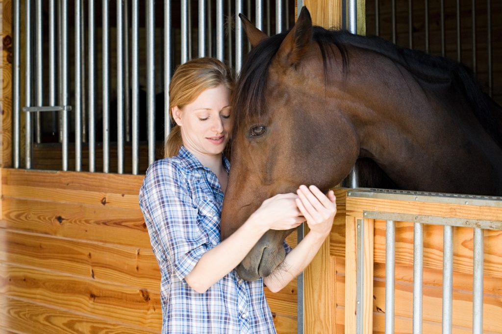 Mid adult woman with horse in stable