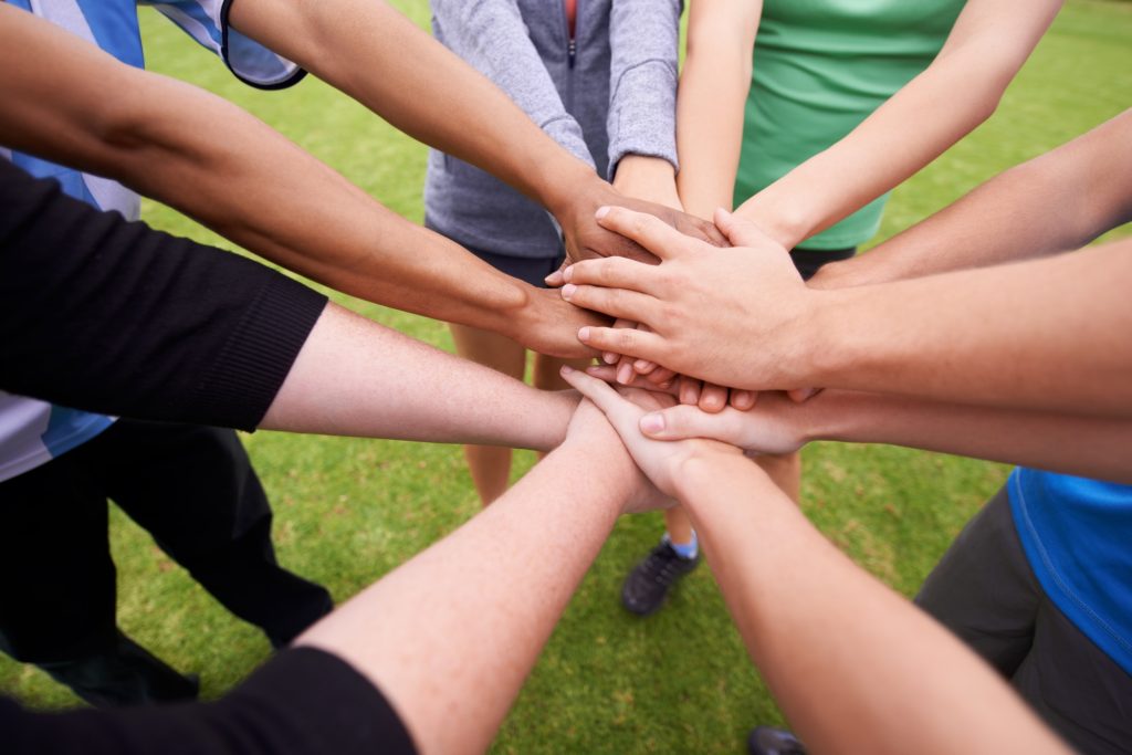On three. Cropped shot of a sports team with their hands in a huddle.